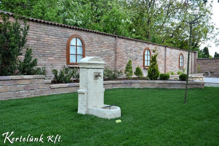 Gyönyörű fehér kút az udvaron, kőből.